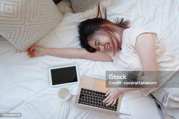 Smiling Asian Businesswoman Is Relaxing And Laying With Laptop In Bedroom On Holiday She Is Online Working From Home With Technology During The Covod19 Outbreak Concept Stock Photo - Download Image Now