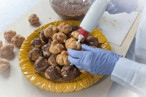 istock Preparation of profiteroles with cream and chocolate 1394906667