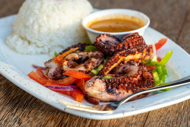 Fried octopus tentacles with white rice on a plate, close up stock photo