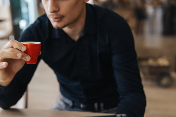 istock Handsome young man drinking coffee and using digital tablet at restaurant 1394912545