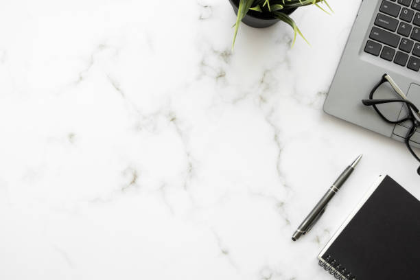 istock White marble office desk table with laptop computer and office supplies. Top view with copy space, flat lay. 1394913178
