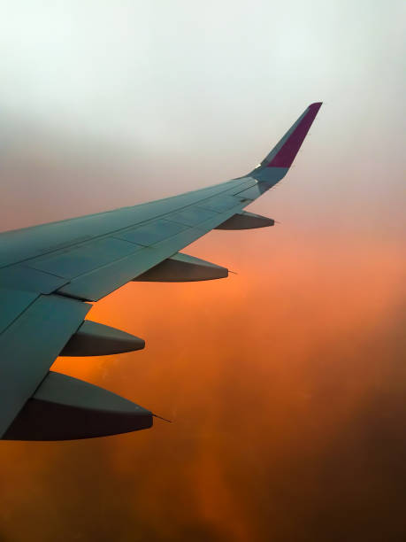 istock Hazy airplane wing view sunny cinematic panorama during flight over land copy paste vertical background 1394913421