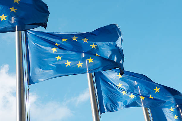 Four European Union flags waving in the wind stock photo