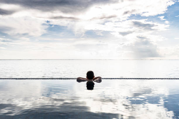 istock Little kid looking the ocean from a infinity pool 1394914671