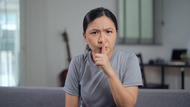 アジア人女性が唇に人差し指を当て、秘密を守る。 - hand sign stop gesture talking discussion ストックフォトと画像