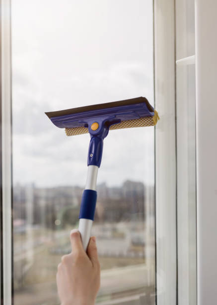 istock hand cleaning window glass with sponge mop 1394917863
