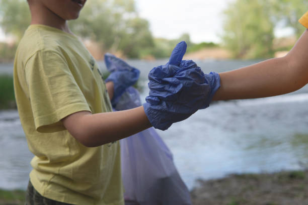 istock Children shaking hands in blue gloves. 1394920646