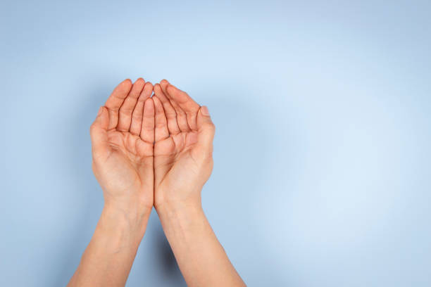 manos de palma ahuecadas vacías, manteniendo las manos juntas sobre fondo azul claro. vista superior a las manos extendidas de la mujer. cuidado, ayuda, apoyo, caridad, concepto de donación - manos ahuecadas fotografías e imágenes de stock