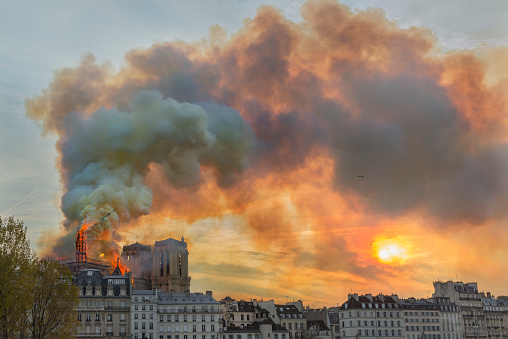 The spire on the back roof of Notre-Dame Cathedral burning and falling.