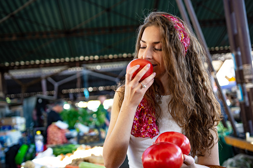 Young woman buying tomatoes at the market
