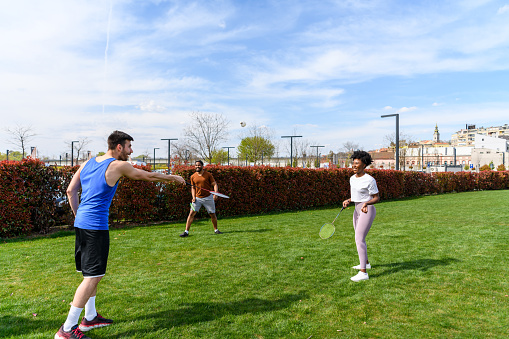 A Young Man is Playing Badminton at the Playground with his African Female Friend.