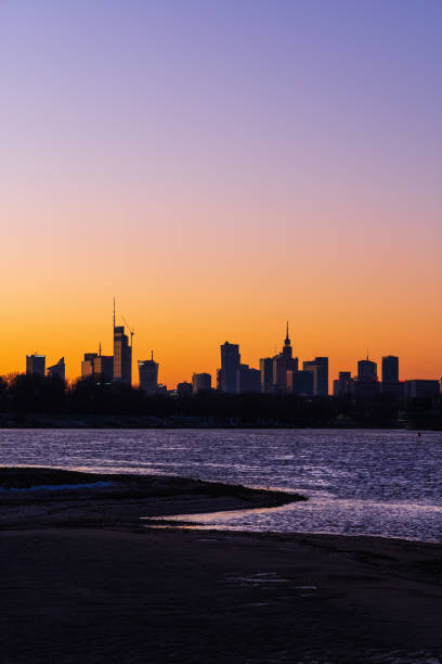 Poland, Warsaw, clear twilight sky above city skyline, river view.