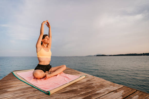 istock Young Woman Meditating On The Pier 1394923842