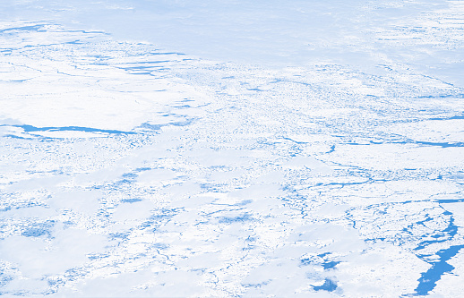 Seen from the sky sea ice covering the Southern ocean near Antarctica coasts with blue sky and few clouds