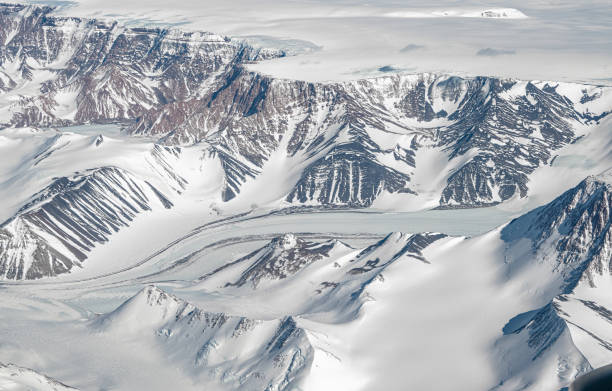 antarctic glacier tongue flowing through mountains cliffs - climate change south pole antarctica imagens e fotografias de stock