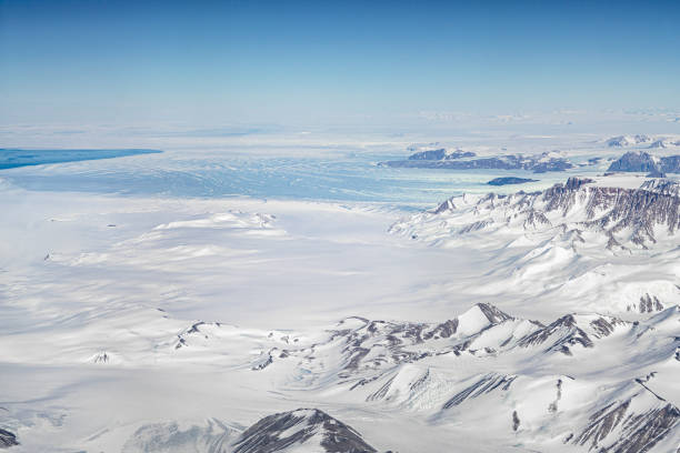 der antarktische gletscher, der durch die berge fließt, reicht bis zum meer - terra nova bay stock-fotos und bilder