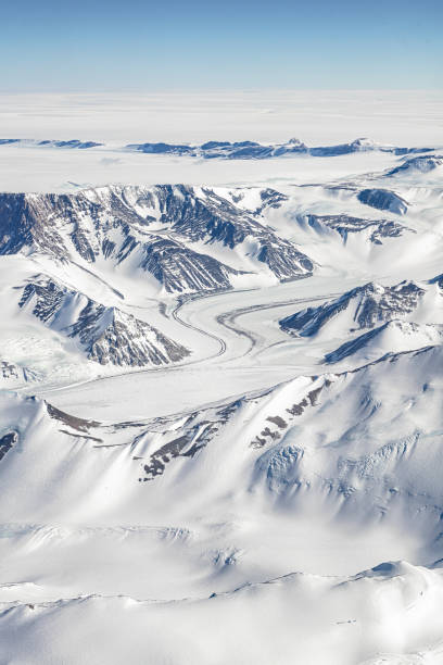 antarktische gletscherzunge, die durch bergklippen fließt - terra nova bay stock-fotos und bilder