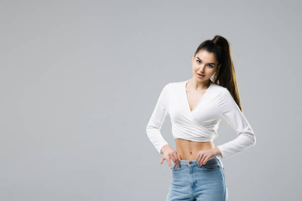 istock Smiling brunette woman posing looking at the camera over white background 1394926913