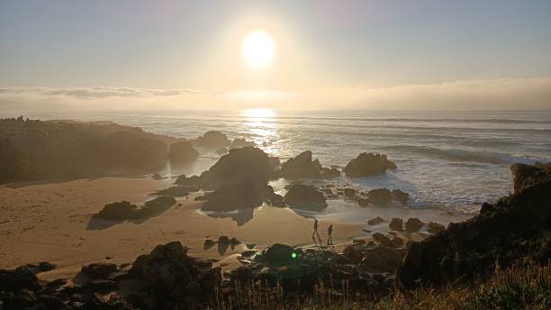 istock Sunset on a beach with waves and rocks. Dunes with grass and waves 1394927060