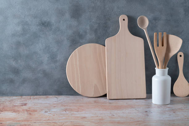 istock Modern kitchen kitchenware in light wood color with ladle, cutting boards and cookware on gray 1394927648