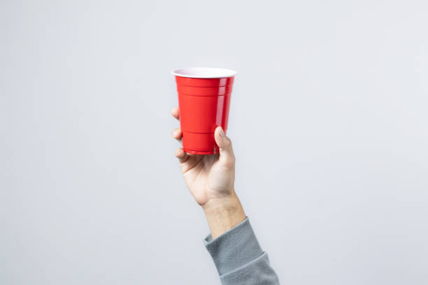 Hand raising the red cup, Copy space. Hand raising the red cup, Copy space. red party cup stock pictures, royalty-free photos & images