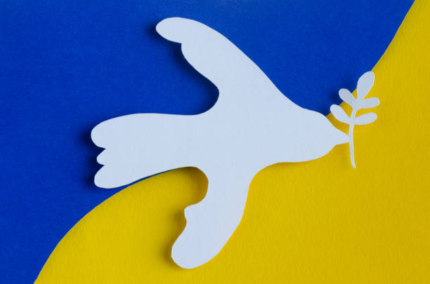 istock White dove with olive branch on Ukrainian flag. Copy space. 1394932000