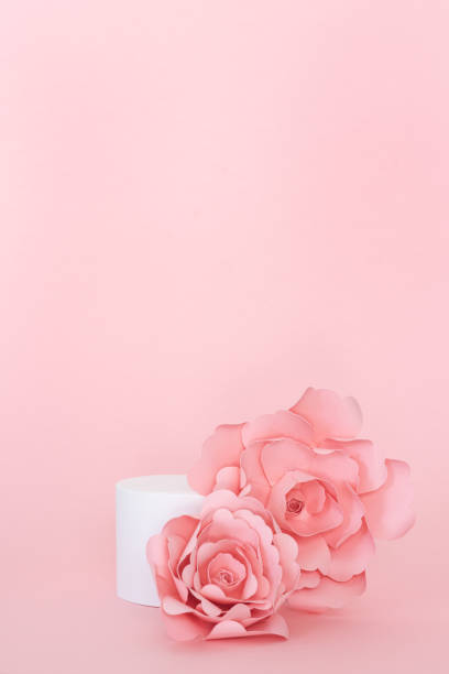 istock Blank circular platform for product presentation with paper roses on pink background. Copy space. Vertical photo. 1394932004