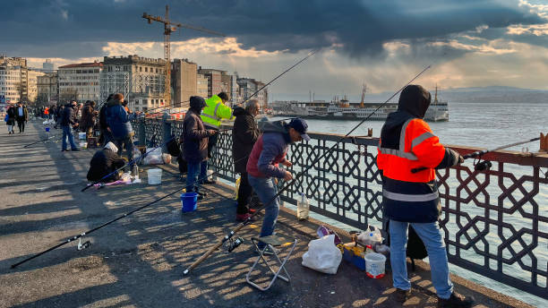 Istanbul, Turkey, March 25, 2022 - Fishermen on a typical morning on the Galata Bridge in Istanbul, Turkey.