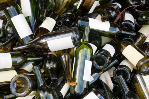 A large heap of empty green wine bottles