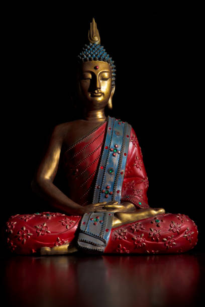 sitzende buddha-statue in lotusposition. die statue ist in hellen farben gehalten und mit farbigen kristallen eingelegt. - buddha image stock-fotos und bilder