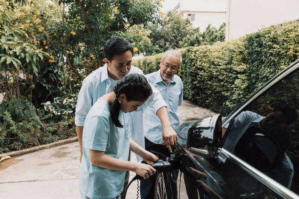 istock Father explaining use of electric car charger. 1394936496