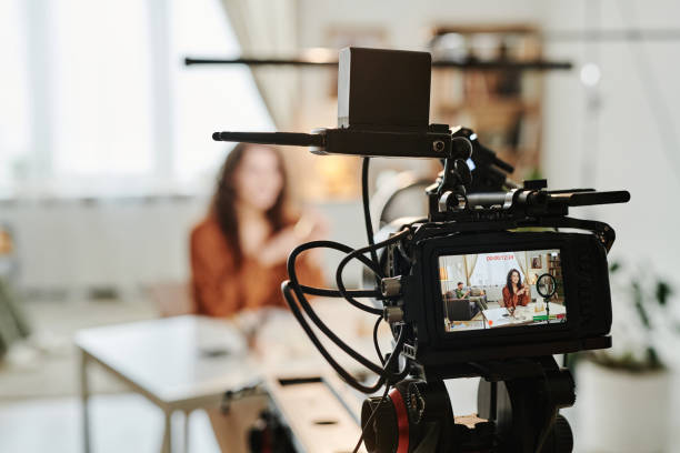 istock Video camera with young female blogger or advert model on screen 1394939467