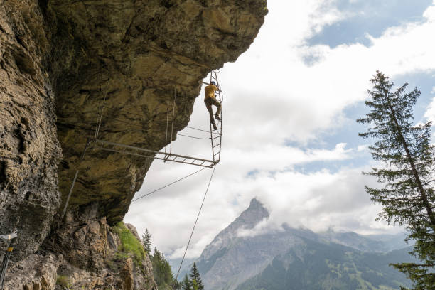 istock Man on Via Ferrata climbing up on ladder against sky 1394942406