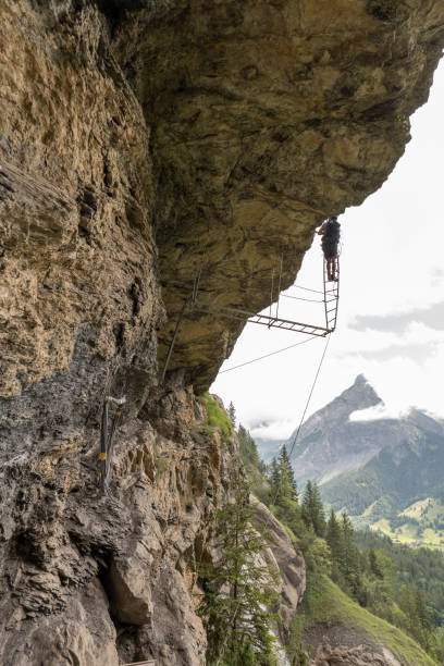 istock Man on Via Ferrata climbing up on ladder against sky 1394942464