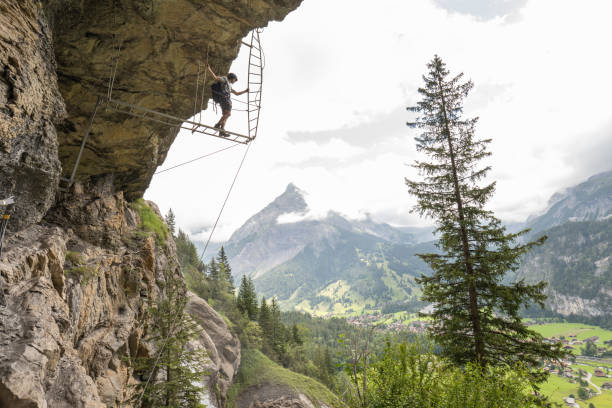 istock Man on Via Ferrata climbing up on ladder against sky 1394942477