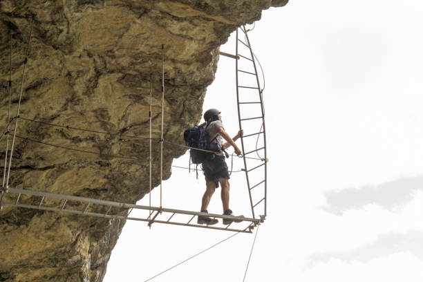 Wide angle view of sporty man climbing in summer on Via Ferrata in Switzerland