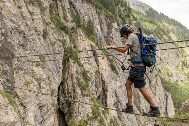 istock Man on Via Ferrata crossing monkey bridge 1394943408