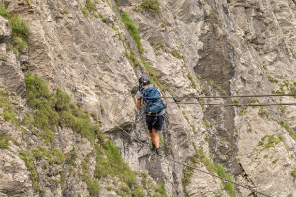 istock Man on Via Ferrata crossing monkey bridge 1394943536