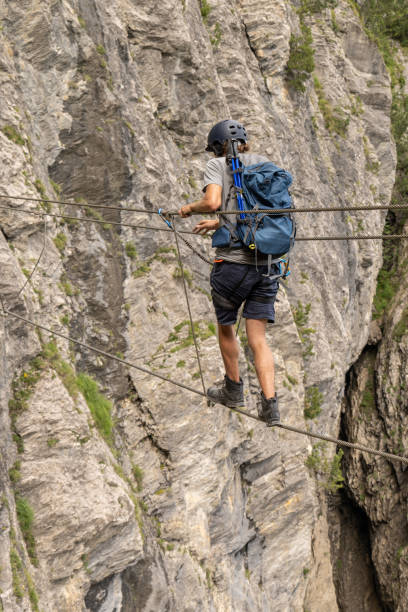 istock Man on Via Ferrata crossing monkey bridge 1394943593