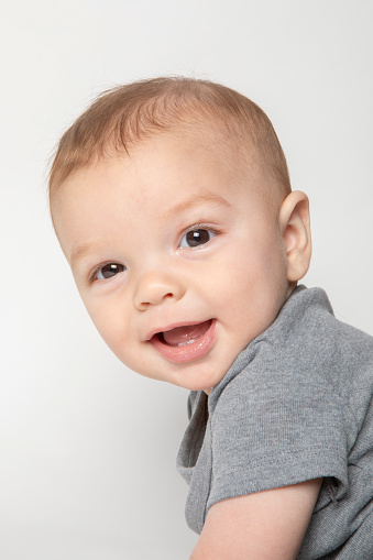 Portrait of a cute baby against gray background