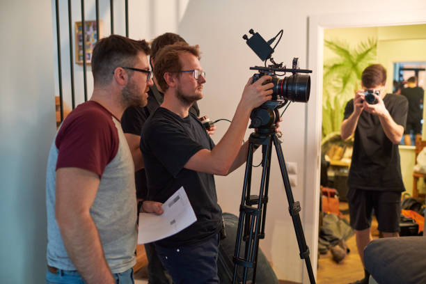 istock Young cameraman or videographer adjusting focus of camera before shooting 1394944115