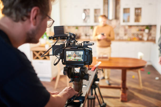 istock Young male videographer standing by video camera while shooting advertisement 1394944118