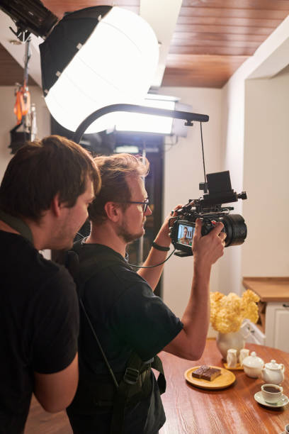 istock Young videographer and his assistant preparing video camera for shooting 1394944124