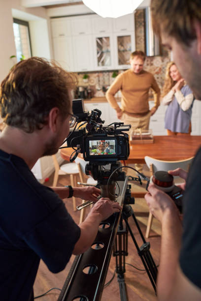 istock Young videographers moving video camera along slider during shooting 1394944132