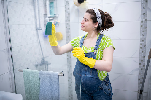 Pregnant woman cleaning the bathroom.