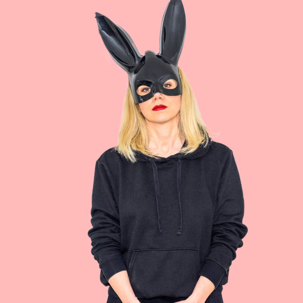 istock Serious blond woman wearing a rabbit mask with bunny ears 1394947104