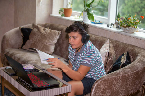 istock Close up of a young boy studying and doing homework using his laptop 1394947247