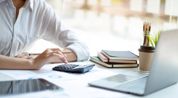 istock Asian accountant working and analyzing financial reports project accounting with chart graph and calculator in modern office, finance and business concept. 1394947359