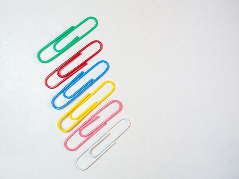 Large multi-colored paper clips. Paperclip of documents. Desktop. Bright stationery\