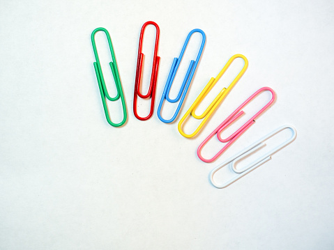Large multi-colored paper clips. Paperclip of documents. Desktop. Bright stationery\